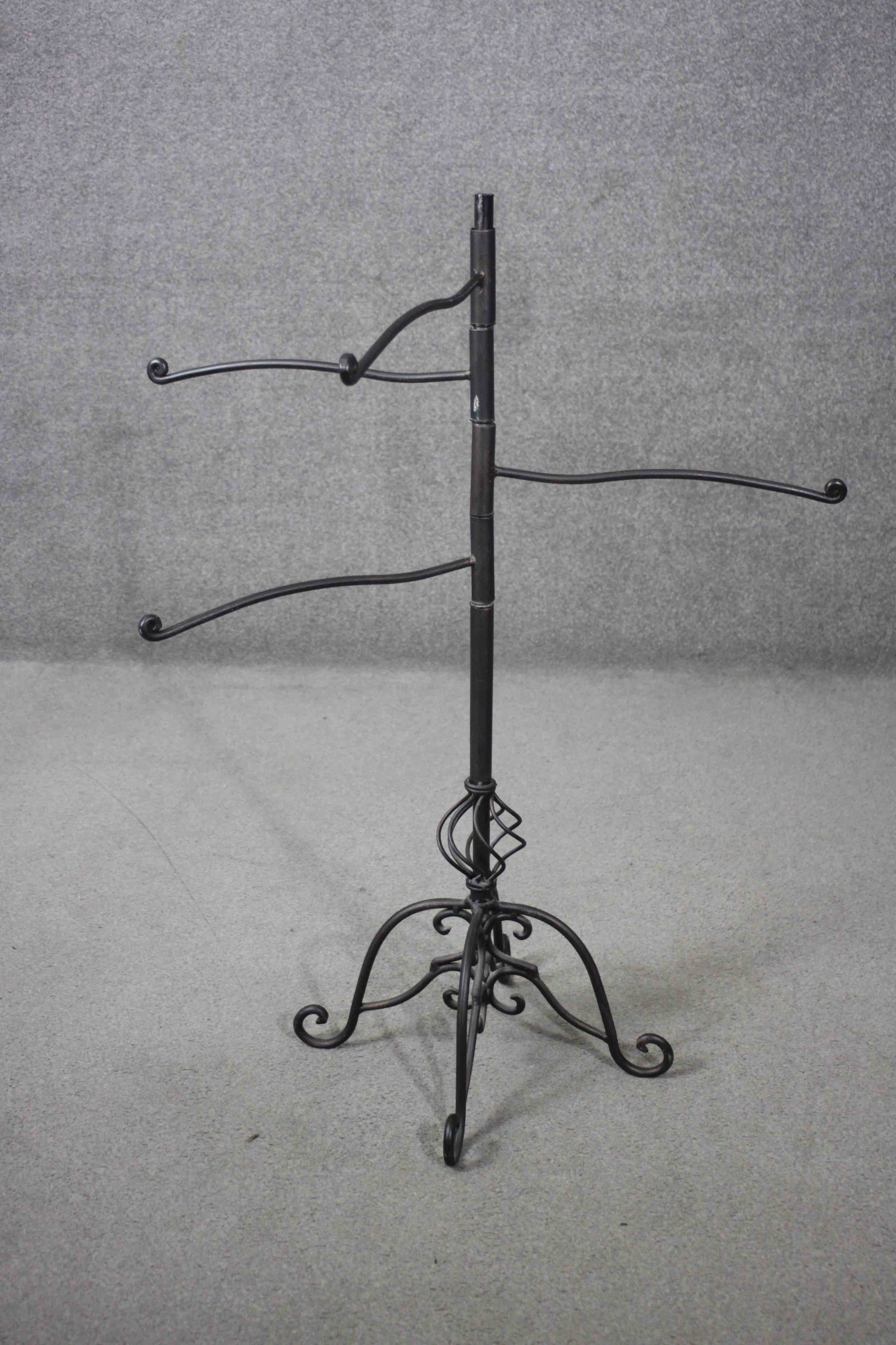 A Victorian style cast iron revolving towel rail with scrolling design base. H.102 W.106 D.40 cm.