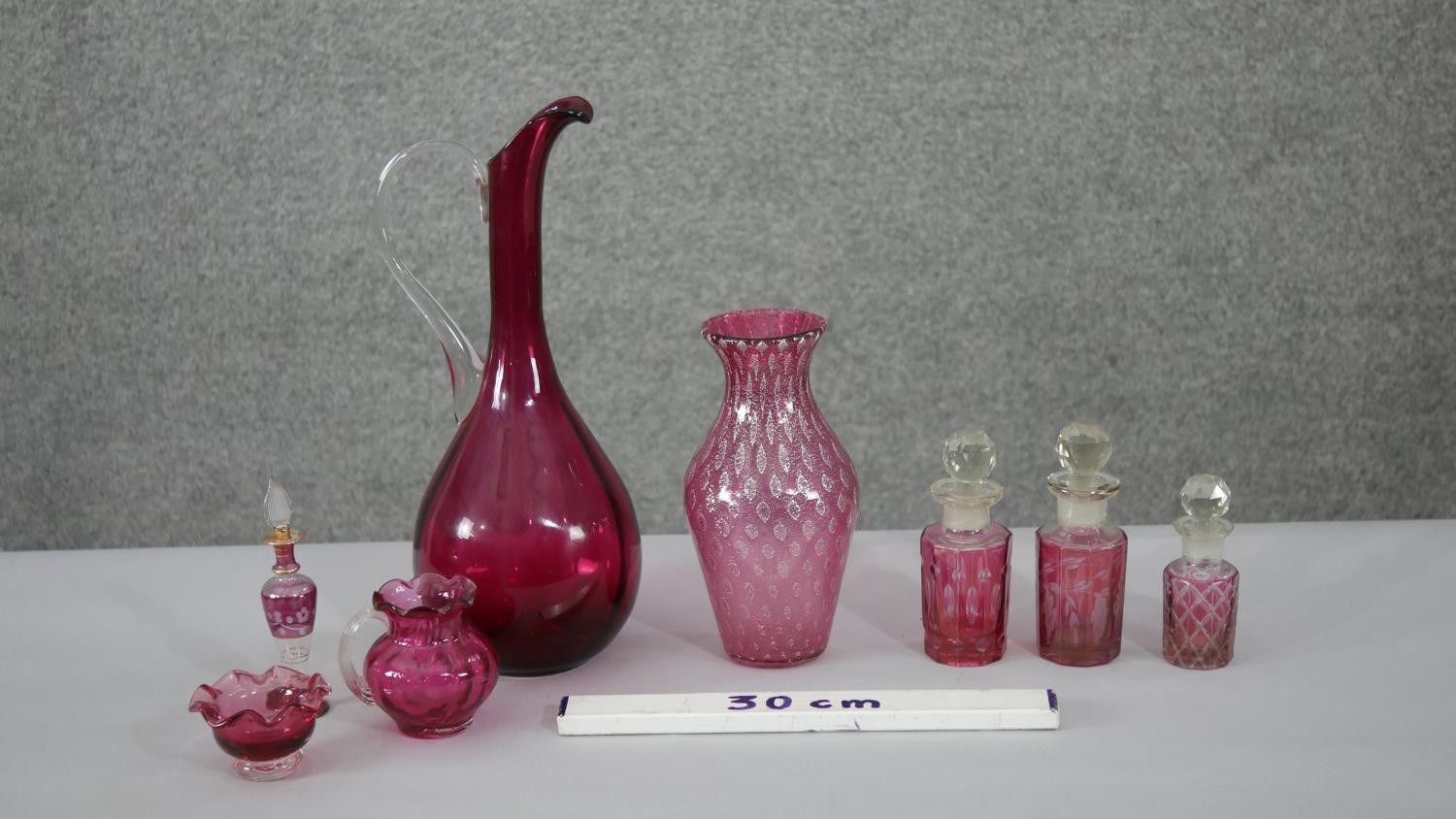 A collection of cranberry glass. Including an art glass water jug, a fishnet pattern golf foil art - Image 2 of 6