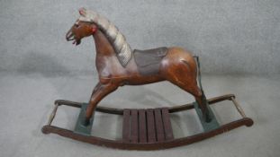 A vintage carved and painted rocking horse on platform base. H.80 L.125cm