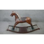 A vintage carved and painted rocking horse on platform base. H.80 L.125cm