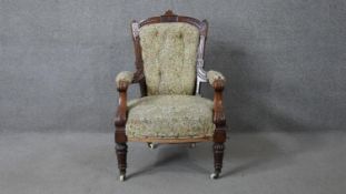 A late Victorian carved walnut frame armchair in floral upholstery on tapering fluted supports.