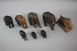 Eight carved animals. Including seven elephants some ebony and a Blackforest wild boar. H.13 W.12