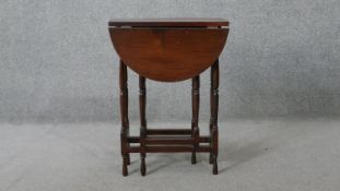 A vintage teak drop flap table on turned stretchered gateleg supports. H.62 W.60 D.45 cm