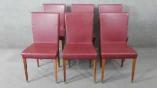 A set of six contemporary high back dining chairs in faux leather upholstery.