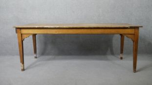 A 19th century elm planked top refectory style farmhouse dining table with shaped frieze and end