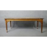 A 19th century elm planked top refectory style farmhouse dining table with shaped frieze and end