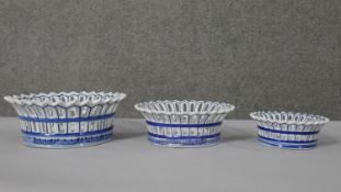 A set of three Chinese style blue and white pottery bowls with pierced galleries depicting fish