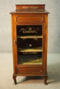 A late 19th century mahogany glazed cabinet with velvet lined interior and later painted Chanel
