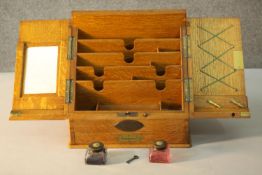 A late 19th century oak stationery box, with hinged doors opening to reveal a fitted