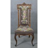 A Victorian carved rosewood prie dieu chair with barleytwist pilasters and floral tapestry