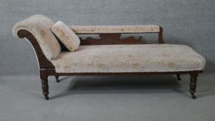 A Victorian carved walnut framed chaise longue on turned tapering supports. H.73 W.157 D.59cm