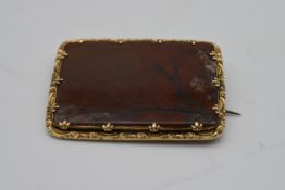 A Victorian yellow metal brooch set with a panel of red Jasper, in foliate form claws, hinged pin to
