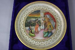 A blue velour cased Indo-Persian hand painted and gilded marble plate. Decorated with figures within