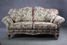 A 19th century two seater sofa in floral tapestry style upholstery on turned mahogany supports