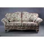 A 19th century two seater sofa in floral tapestry style upholstery on turned mahogany supports