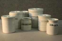 A collection of seven early 20th century ceramic lidded food storage jars. Each with name label. H.