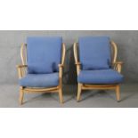 A pair of mid century vintage Ercol style light beech salon armchairs.