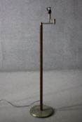 A vintage teak and brass standard lamp with hinged arm. H.134 Dia.30cm.