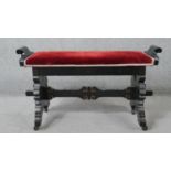 A late 19th century ebonised duet stool with stretchered lion carved supports. H.54 W.95 D.40cm