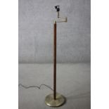 A vintage teak and brass standard lamp with hinged arm. H.143 Dia.30cm.