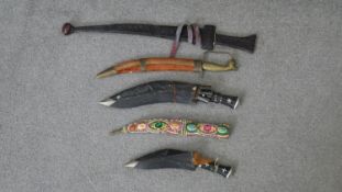 A collection of five early 20th century Indian daggers. One with a fabric sheath with faux gem