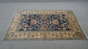 A Chubi rug with scrolling foliate decoration on a sapphire ground within floral multiple borders.