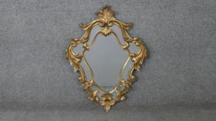 A carved giltwood Florentine style wall mirror. H.73 W.52cm