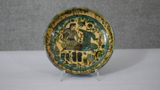 A Persian glazed ceramic bowl, decorated with two figures drinking to centre, dated and marked to