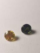 A loose round brilliant cut yellow moissanite and a round mixed cut loose green sapphire.