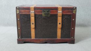 A 19th century style faux crocodile skin travelling trunk with leather straps and lined interior.