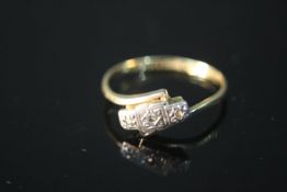 A Edwardian 9 carat yellow gold and diamond cross over ring. Set with three old cut diamonds in star