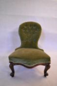 A Victorian mahogany nursing chair in deep buttoned upholstery on carved cabriole supports. H.88 W.