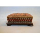 A Victorian mahogany footstool in original tapestry upholstery on squat bun feet. H.15 W.36 D.33cm