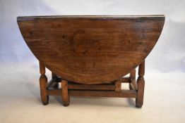 An 18th century country oak gateleg dining table with frieze drawer above turned stretchered