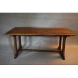 A C.1900 Arts and Crafts oak refectory style dining table on stretchered trestle platform