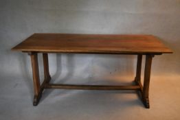 A C.1900 Arts and Crafts oak refectory style dining table on stretchered trestle platform