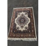 A handmade Indian Jaipur rug with central floral medallion on a cream ground within floral