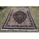 An Indian Jaipur carpet with floral central medallion on midnight ground within naturalistic