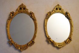 A pair of mid century gilt plaster Rococo style wall mirrors with cherub cresting. H.69 W.44cm