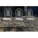 A set of three vintage white painted wrought metal folding garden or conservatory chairs.