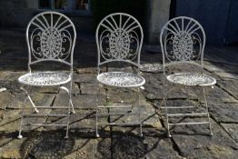 A set of three vintage white painted wrought metal folding garden or conservatory chairs.