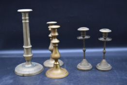 Two pairs of 19th century brass candlesticks and a similar single stick. H.28cm