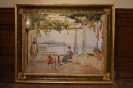 A large gilt framed painting on ceramic tiles depicting a Continental veranda scene, signed E.