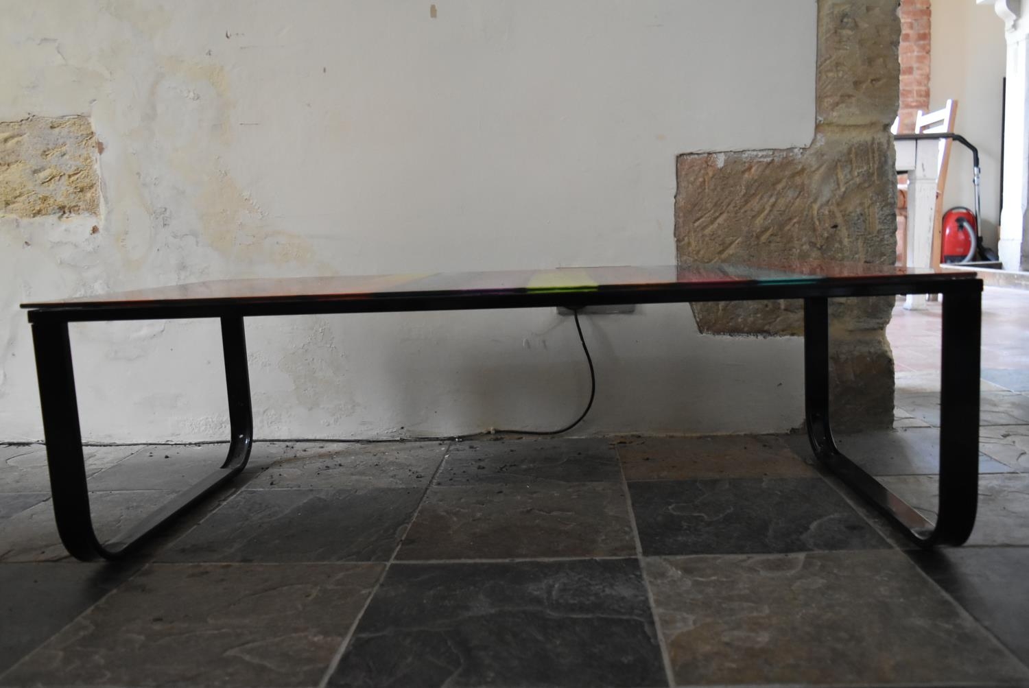 A contemporary metal framed coffee table with polychrome plate glass top. H.32 W.135 D.55cm