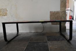 A contemporary metal framed coffee table with polychrome plate glass top. H.32 W.135 D.55cm