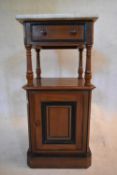A late 19th century walnut and ebonised pot cupboard with marble top above frieze drawer and fielded