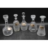 Five miscellaneous Victorian cut crystal decanters with silver drinks labels. Hallmarked. H.34cm