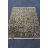 A hand woven Indian Agra rug with scrolling serrated palm design on a biscuit ground within