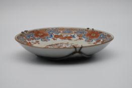 A 19th century Chinese porcelain wall plate decorated with a stylised floral design. H.23cm