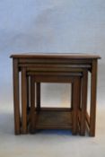 A mahogany nest of three occasional tables with smoked plate glass tops. H.49 W.51 D.42cm